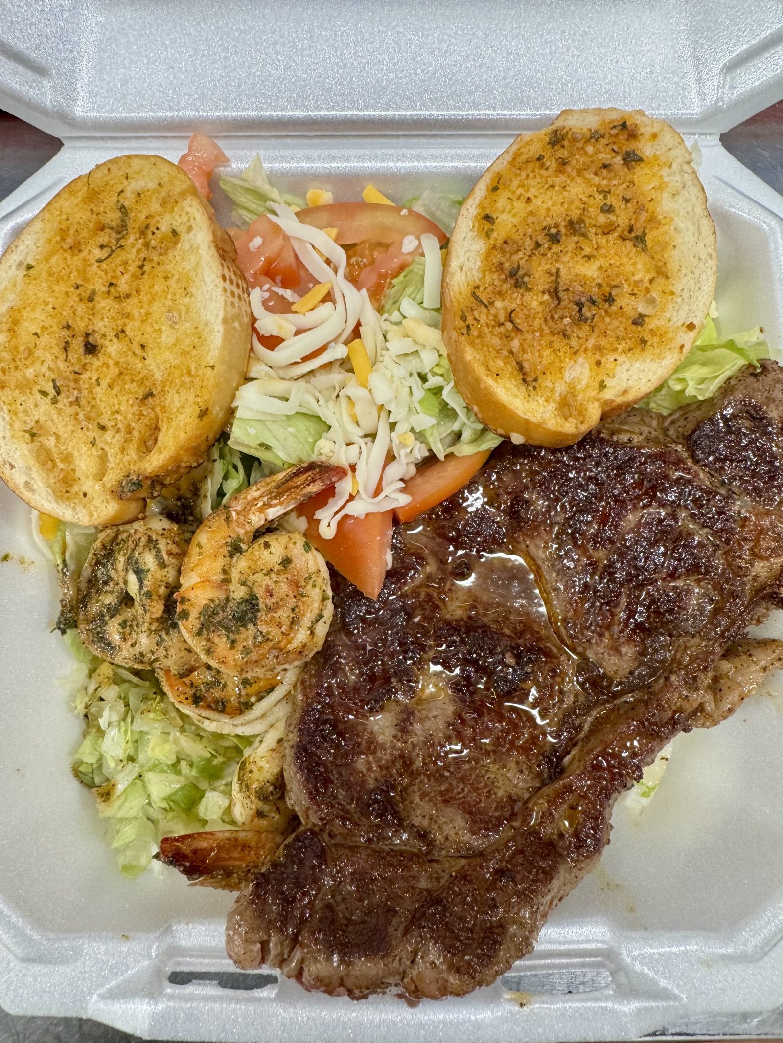 New York steak with shrimp, salad and garlic bread