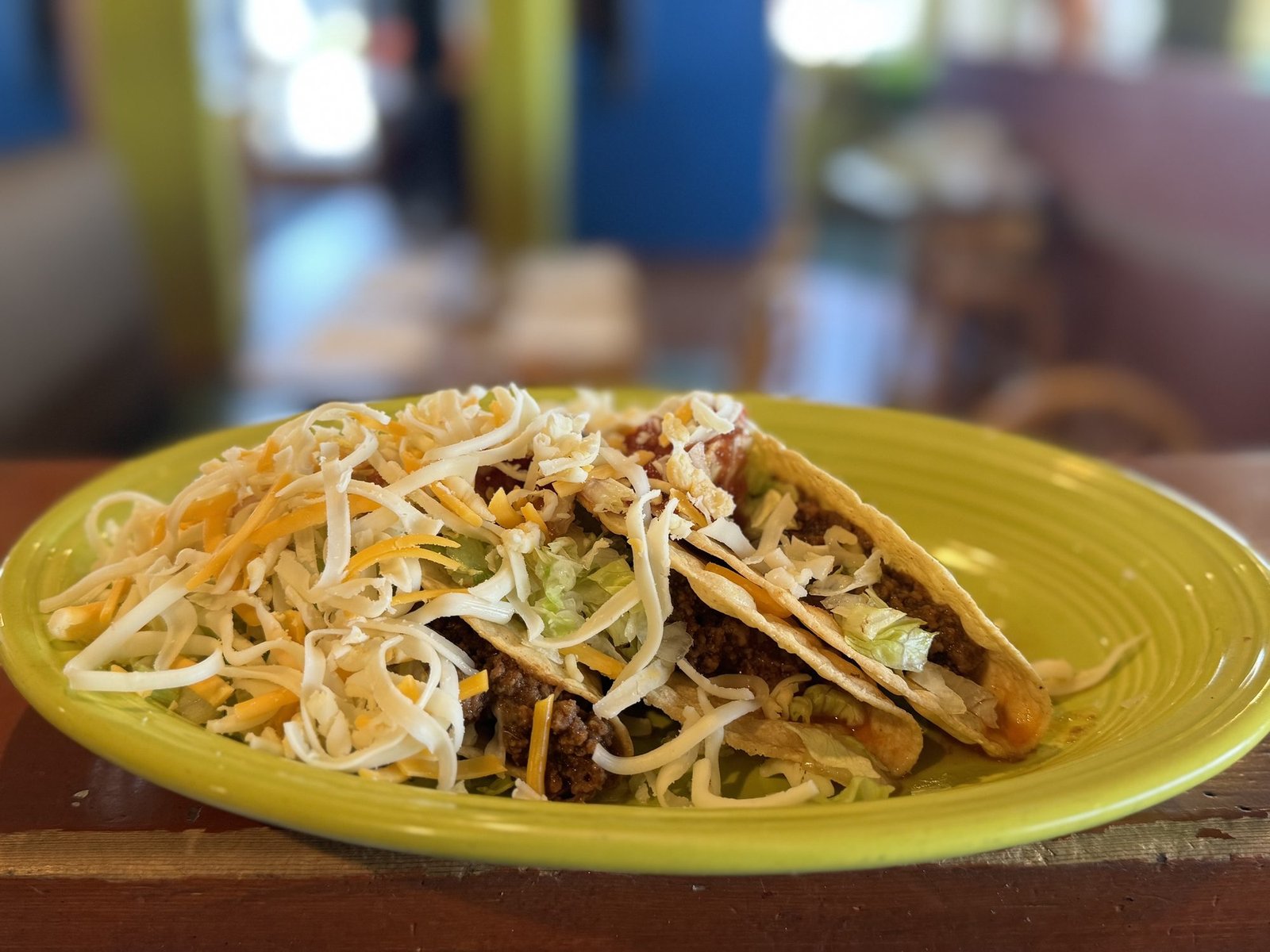 Three tacos served on a yellow plate